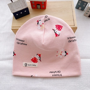 Close-up of pink cotton knitted baby hat featuring cute Christmas cartoon print details