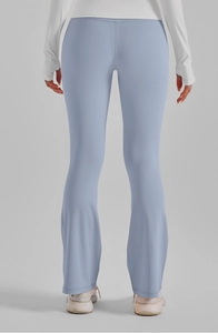 Détail du pantalon de yoga évasé bleu clair à taille haute montrant l'effet galbant