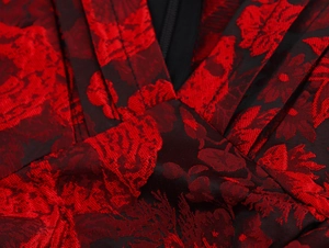 Detailed view of red floral jacquard fabric with V-neckline and black zipper