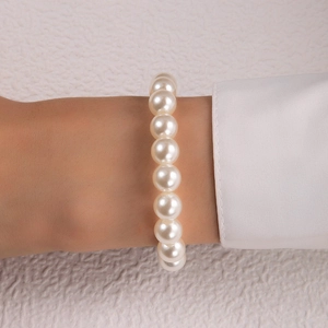 Close-up of elegant single layer white pearl bracelet worn with a white shirt cuff