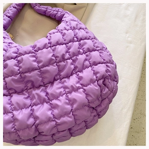 Macro shot of purple quilted puffer tote bag fabric showing cloud-like texture