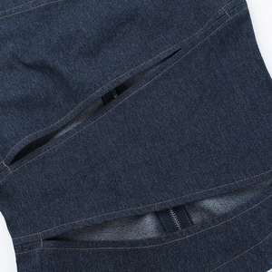 Detail of dark blue denim top featuring functional zipper pocket and precision stitching