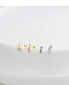 Detailed macro view of S925 silver and 14K gold minimalist zircon bar stud earrings