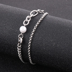 Detailed macro view of silver layered pearl bracelet on a textured display stand