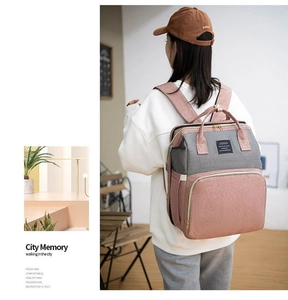 Detail of multi-functional diaper bag showing pink and grey patchwork with padded straps