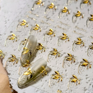 3D gold strawberry embossed nail stickers with metallic relief texture on grey cat-eye nails