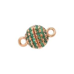 Macro shot of rose gold spherical jewelry clasp with green rhinestones and dual loops
