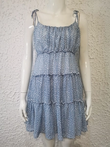 Détail d'une robe d'été fleurie bleue avec buste à volants et jupe à plusieurs niveaux