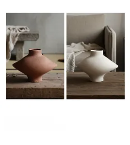 Détail de vases géométriques en céramique avec textures sculptées à la main en rouge et blanc