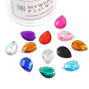 Close-up of teardrop acrylic gems with faceted surface and dual sewing holes for DIY
