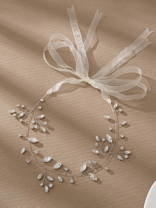 Macro shot of bridal hairband with marquise rhinestones and elegant white ribbon tie