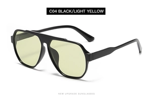 Detail view of large geometric sunglasses with black frame and light yellow lenses