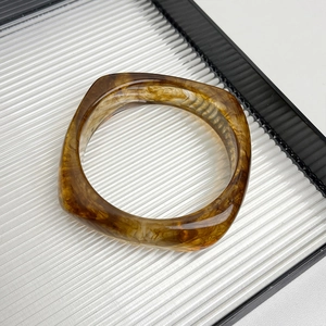 Detailed view of amber resin bangle with square thick design and marble texture