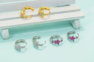 Assorted gold and silver star earrings with micro-set zircon on white wooden stool