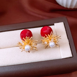 Detail of red globe floral earrings with white pearl and starburst gold finish