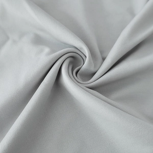 Gros plan du tissu tricoté gris avec texture en sergé doux et détails de drapé