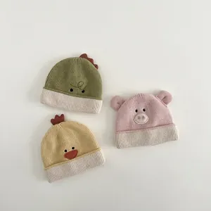 Winter knitted baby hats with cute animal embroidery in pastel green, cream and pink