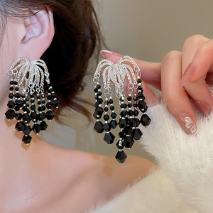 Close-up of vintage silver tassel earrings featuring black faceted crystal beadwork