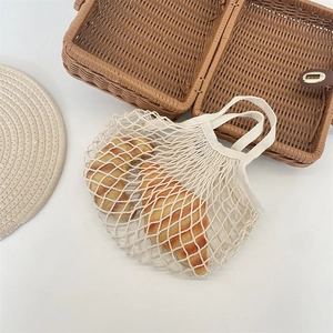 Détail d'un sac filet en coton beige écologique montrant la texture tissée et la maille
