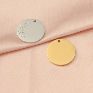 Macro shot of silver star engraved and plain gold stainless steel circular pendants