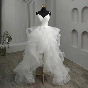 Deep V-neck high-low wedding dress with layered tulle ruffles on a mannequin