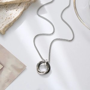 Detailed view of silver and black interlocking rings pendant on a square link chain