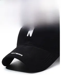 Detailed close-up of white letter N embroidery and stitching on a black cotton baseball cap