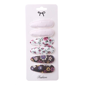 Detail of 6-piece fabric hair clip set featuring pink dots and floral embroidery patterns