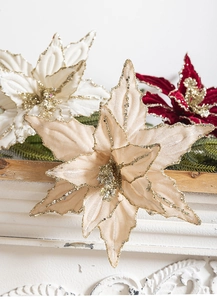 Detail of velvet Christmas poinsettia with glitter sequins on a fireplace mantel