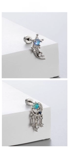 Detailed view of silver moon earrings with light blue zircons and tassel accents