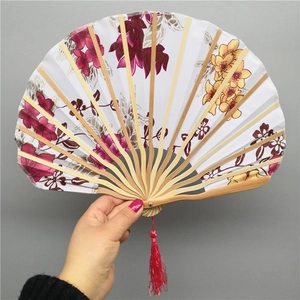 Japanese shell-shaped bamboo folding fan with floral prints and red silk tassel