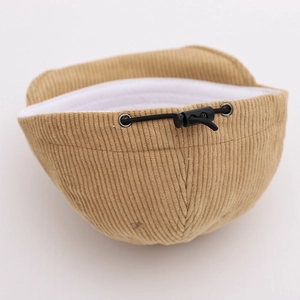 Detail of adjustable elastic drawstring and plastic buckle on corduroy baby cap