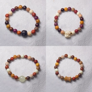 Detail view of multi-color wooden Buddhist prayer beads with lion and elephant carvings