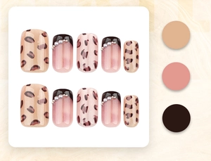 Detail of leopard print press-on nails with French pearl accents on white background
