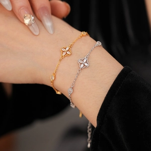 Close-up of zircon clover bracelets in gold and silver finish on model wrist