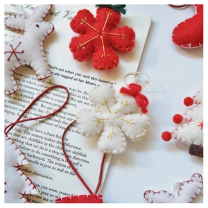 Detailed view of handmade wool felt Christmas ornaments with gold embroidery accents