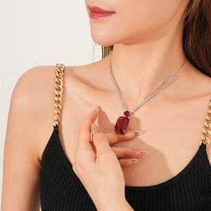 Close-up of a luxury silver chain necklace with a large sparkling red rectangular zircon pendant