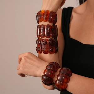 Amber acrylic geometric bangles featuring marbled textures in a retro minimalist style