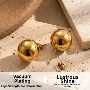 Detail view of gold sphere stud earrings with polished mirror finish and vacuum plating