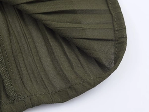 Detailed macro view of dark green pleated fabric texture and professional hem stitching