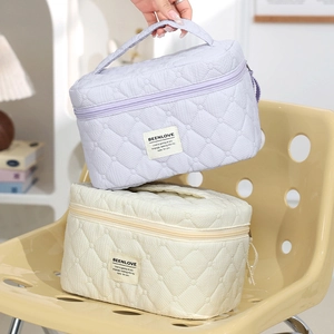 Quilted top-handle makeup bags in light purple and beige for travel organization