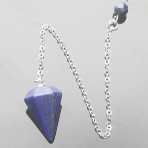 Macro detail of lapis lazuli hexagonal pendulum pendant with stainless steel chain on black surface