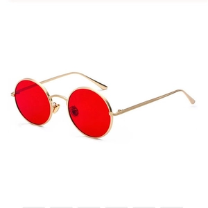 Lunettes de soleil punk rétro avec monture dorée et verres rouges vue à un angle de 45 degrés