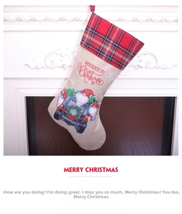 Detail of burlap Christmas stocking with gnome truck print hanging on white fireplace