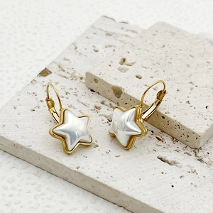 Chic gold-plated star earrings with mother-of-pearl inlays on a stone background