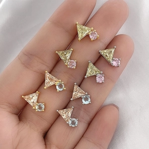 Detailed macro view of geometric earrings with vibrant triangular and round zircon stones