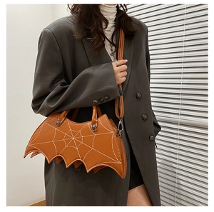 Detail of brown bat-shaped PU handbag with white spiderweb stitching and crossbody strap