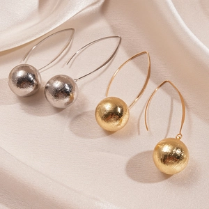 Textured metallic sphere earrings in gold and silver finish on soft silk fabric