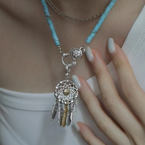 Detail of S925 sterling silver dreamcatcher pendant with turquoise beads and feather charms