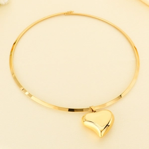 Macro detail of 18K gold plated hollow heart pendant on a minimalist metal collar necklace